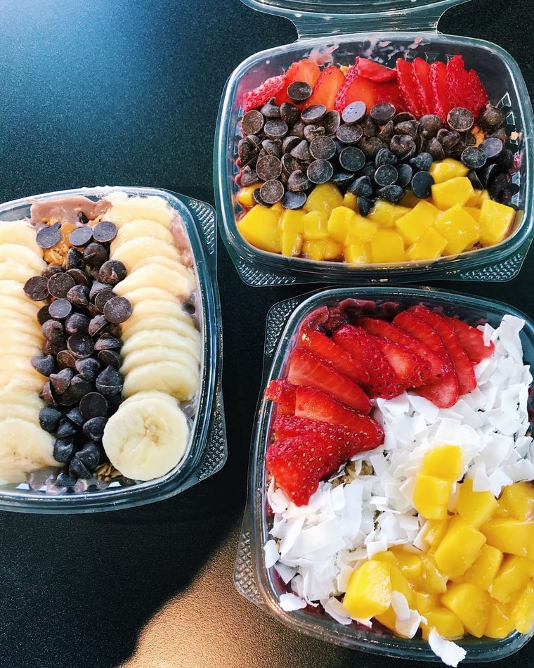 Three Vibe Foods acai bowls topped with strawberries, mango, banana, coconut and chocolate chips